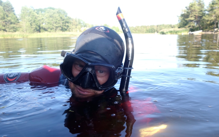 Forskare snorklar i grumlig Östersjövik.