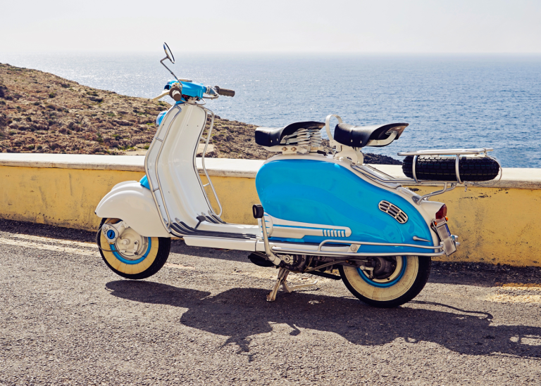 Vintage blåvit scooter parkerad nära kusten