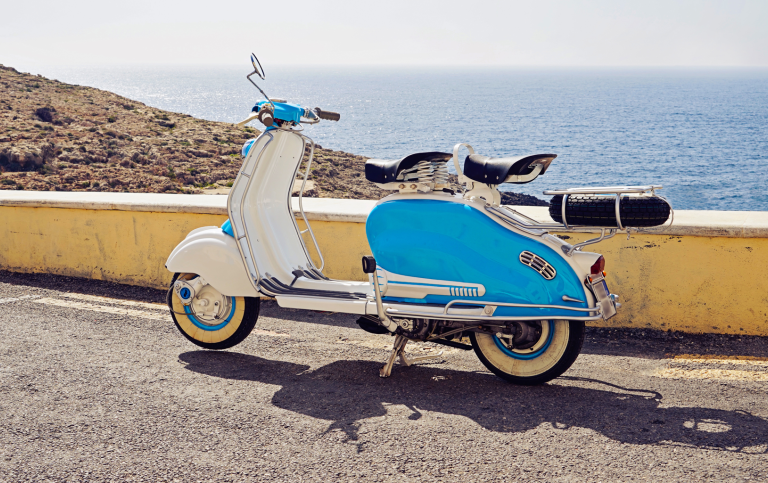 Vintage blåvit scooter parkerad nära kusten