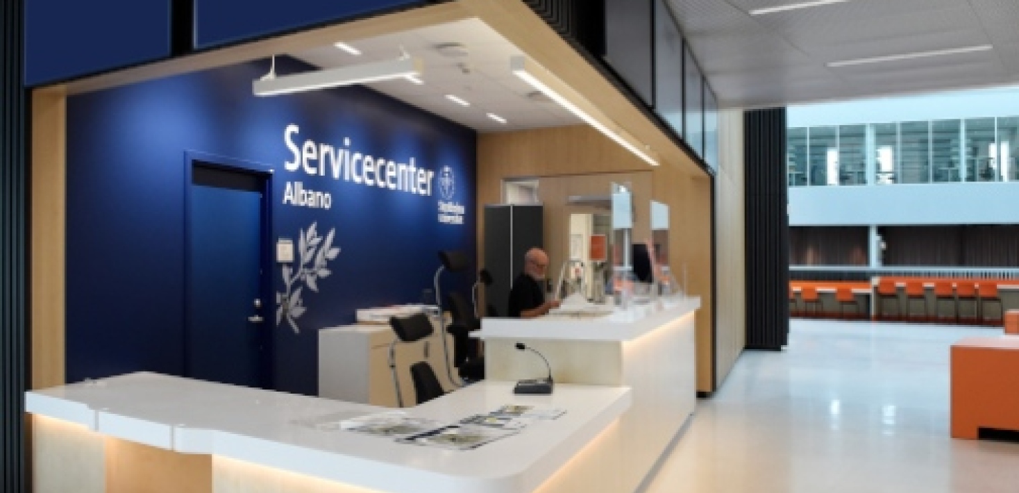 En man sitter bakom servicedisken i Servicecenter Albano.