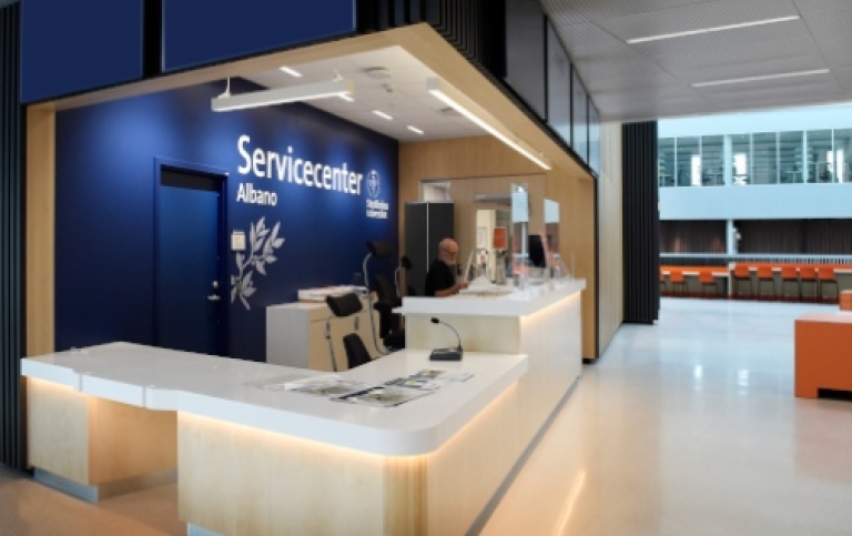 En man sitter bakom servicedisken i Servicecenter Albano.