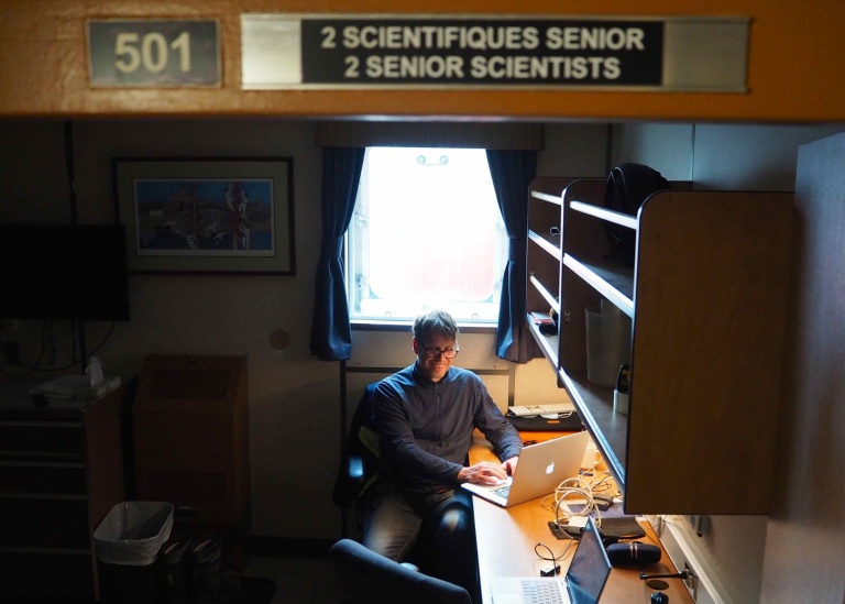 Scientist sitting working on his laptop