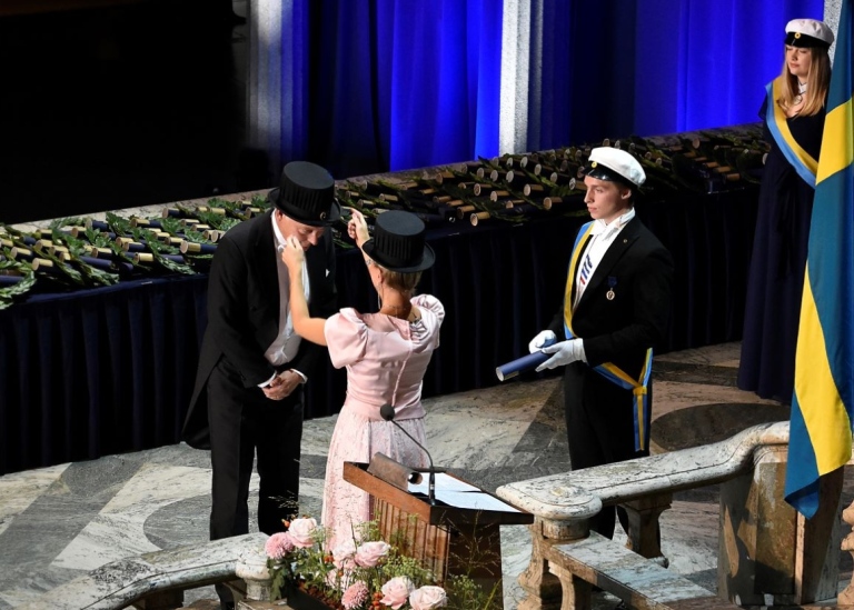 Kvinnlig promotor placerar kransen på Johan Erikssons huvud. Foto: Ingmarie Andersson