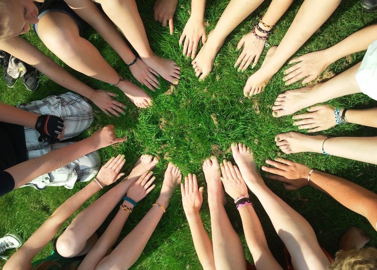 Youth showing their green finger and toe nails, in a ring on grass. Photo: Pixabay.