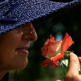 Kvinna luktar på en ros. Foto: suju-foto från Pixabay.