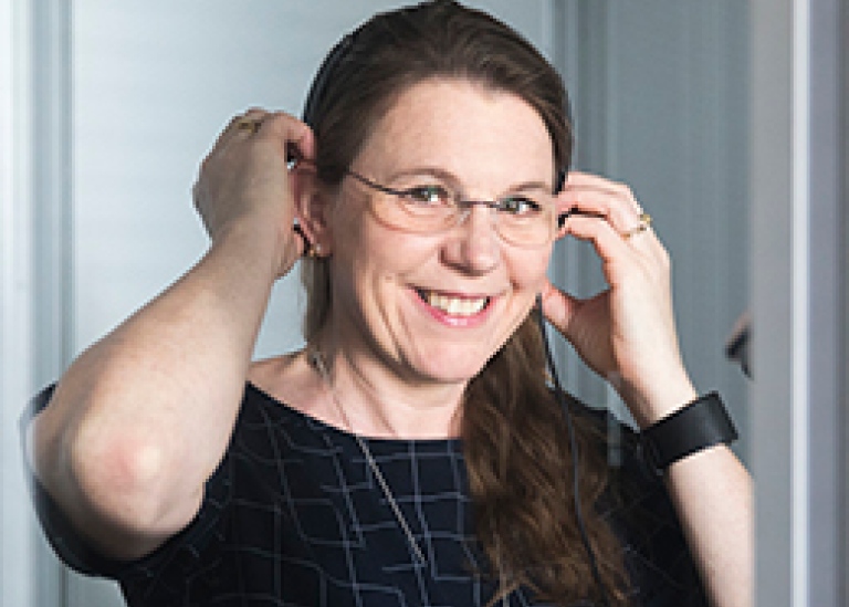 Elisabet Tiselius som sätter på sig ett headset. Foto: Niklas Björling