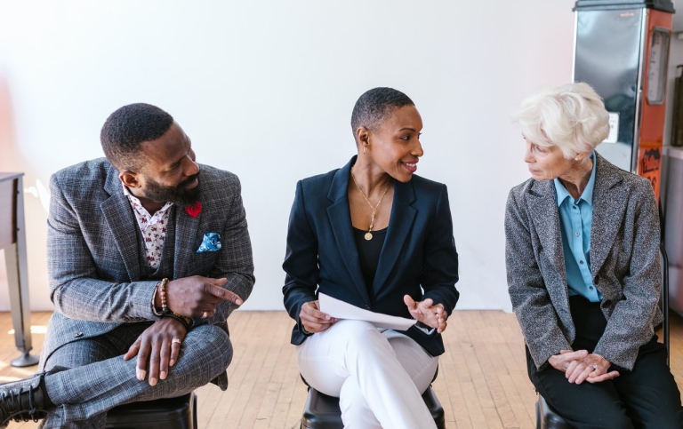 A man and a woman listening to an older lady at work. Photo: RODNAE Productions from Pexels.