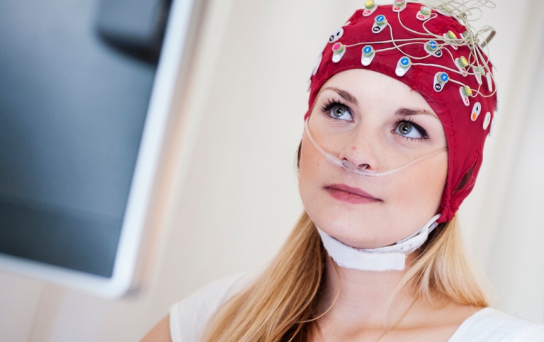 Student with an EEG cap typing on keyboard.