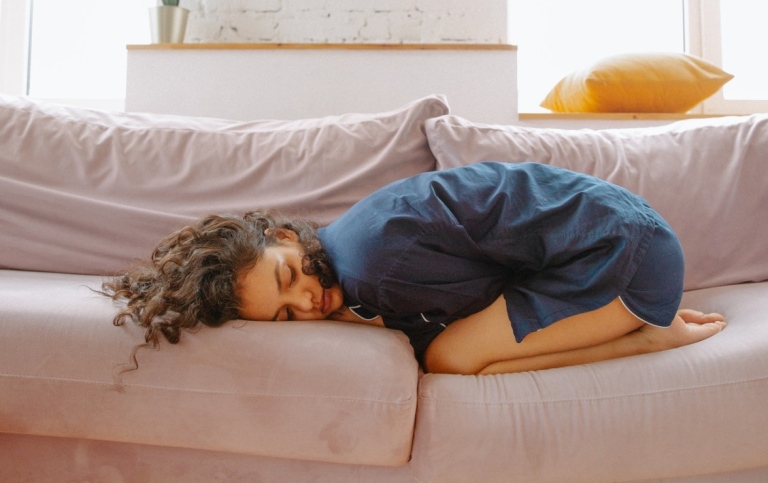 Woman with stomach pain in sofa. Polina Zimmerman från Pexels.