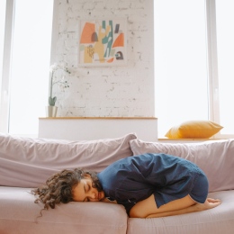 Woman with stomach pain in sofa.