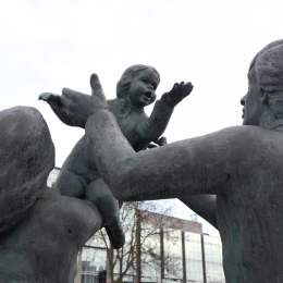 Statues of adults arguing over a child.