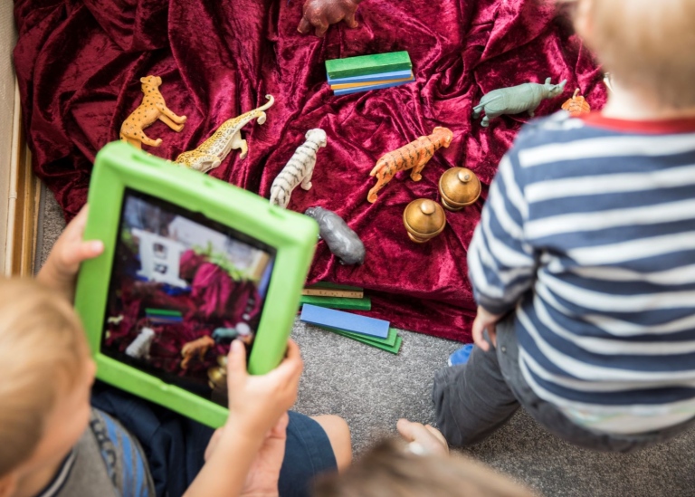 Förskolebarn filmar leksaker med en padda.