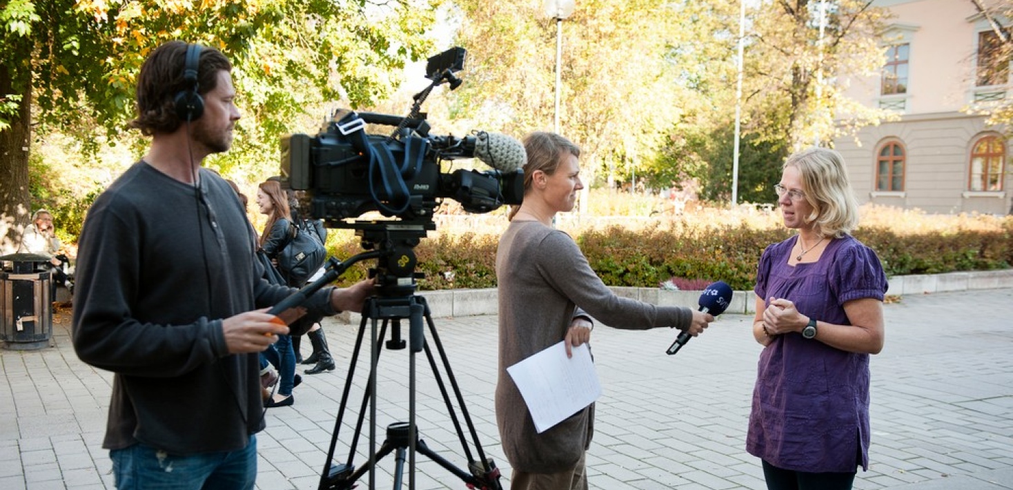 Intervju för tv med en kvinnlig forskare, utanför Stockholms universitet