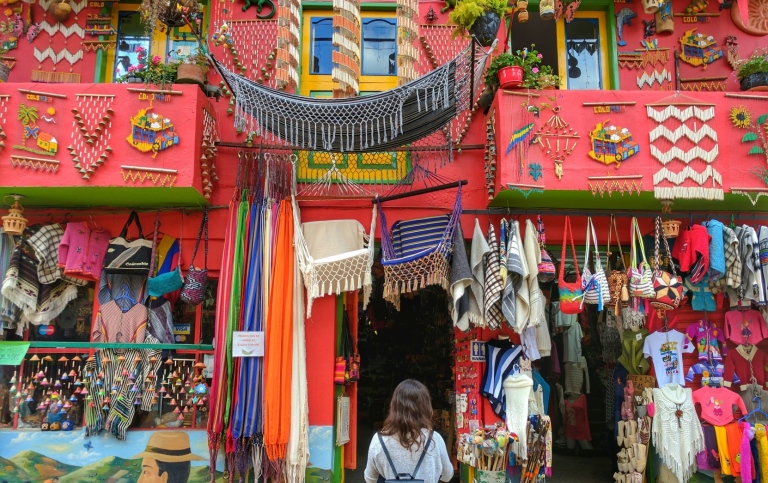 Woman stand in front of red house Ráquira, Colombia Fuente: https://unsplash.com/photos/KBU5gcmK3Dk 