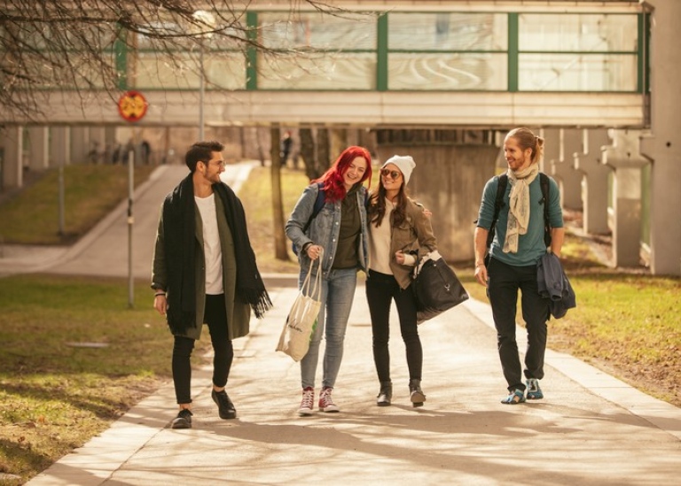Studenter som går utomhus på campus i grupp