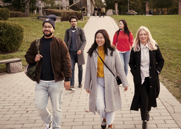 En grupp studenter promenerar på campus.