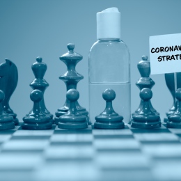 Coronavirus concept image chess pieces and hand sanitizer on chessboard