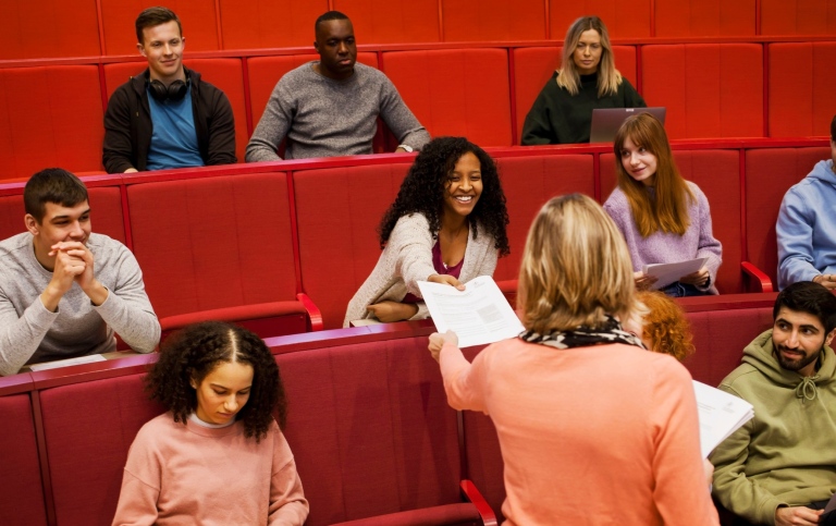 A lecturer with students in a seminar room.