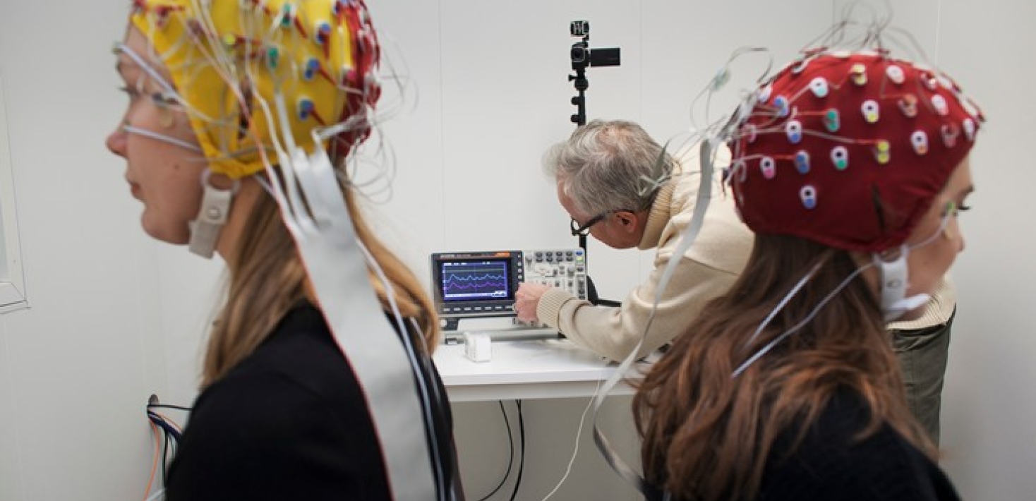 Researcher in lab with two students wearing EEG caps. Photo: Jens Olof Lasthein