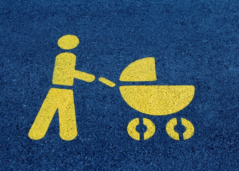 Ikon föreställande vuxen person med barnvagn.