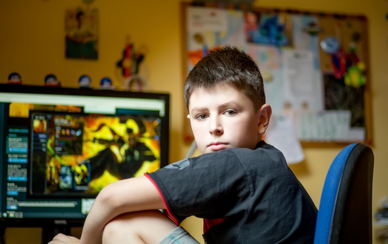 Pojke sitter hemma framför en dataskärm