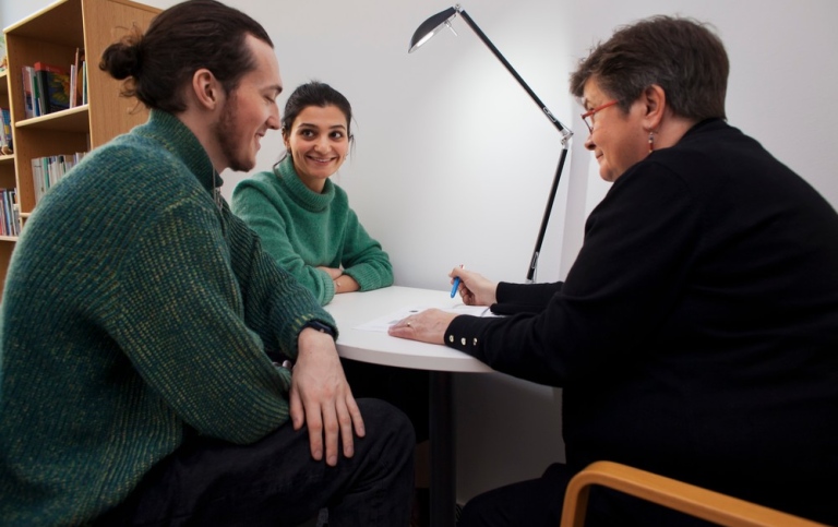 Två studenter får handledning hos Studie- och språkverkstaden.