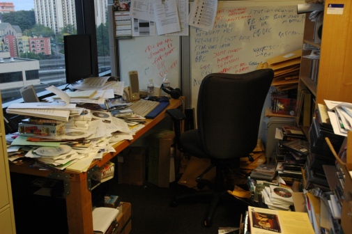 Office table with pile of papers.