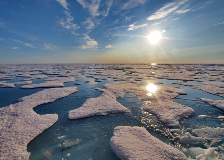 Arktiska havet: hav, isflak, himmel, sol.