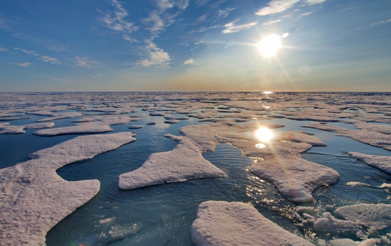 Arktiska havet: hav, isflak, himmel, sol.