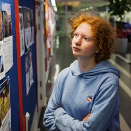 Ung tjej läser på en anslagstavla.