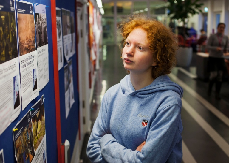 Ung tjej läser på en anslagstavla.