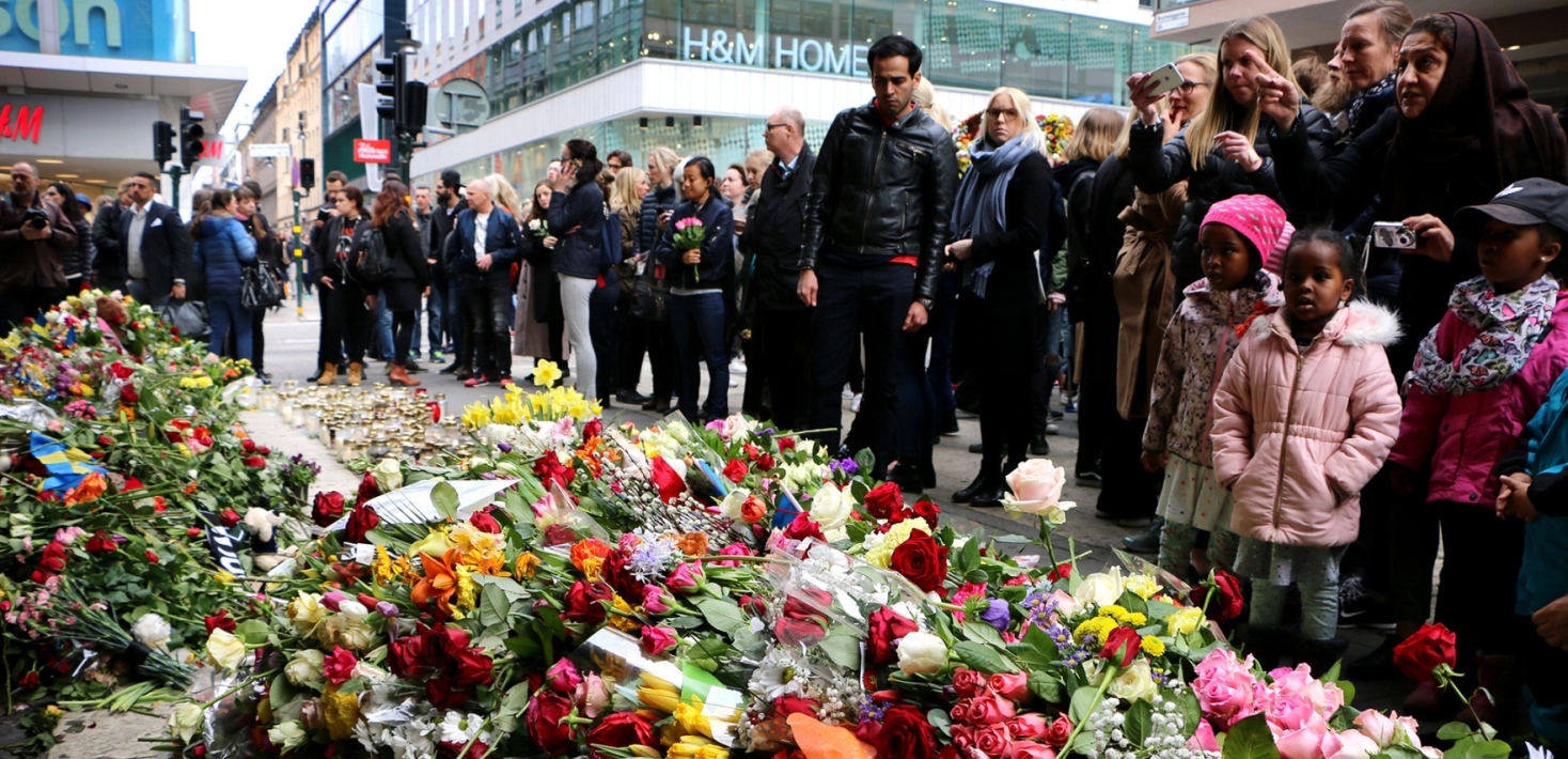 Blommor samlas vid platsen för terrorattentatet på Drottninggatan 2017