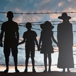 Silhouette Of Refugee Family Standing Near Fence