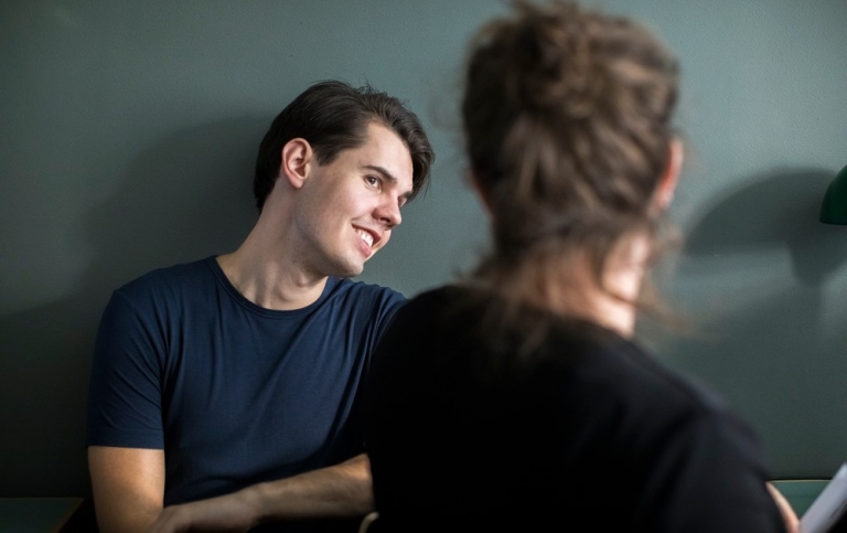 Två studenter talar med varandra.