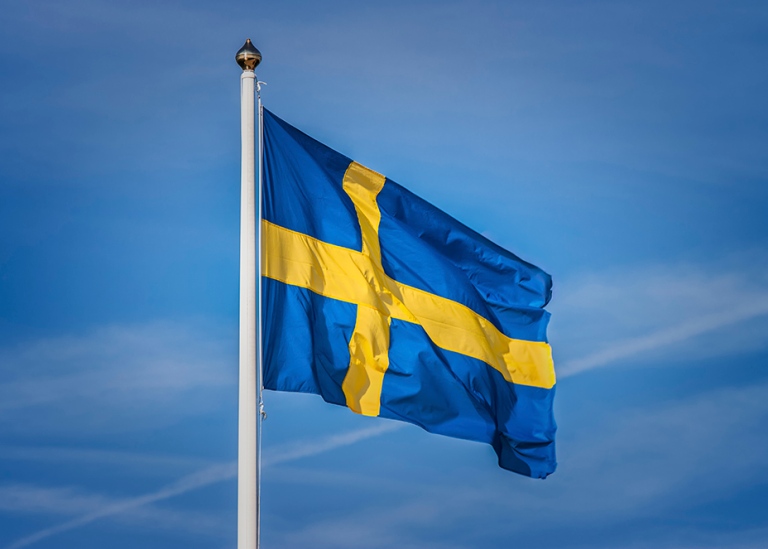 Den svenska blågula flaggan mot blå himmel. Foto: Marie Wennersten, MostPhotos
