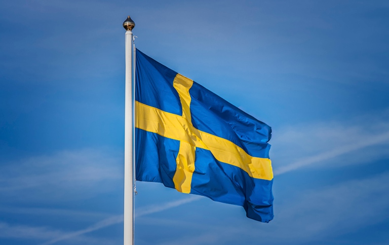 Den svenska blågula flaggan mot blå himmel. Foto: Marie Wennersten, MostPhotos