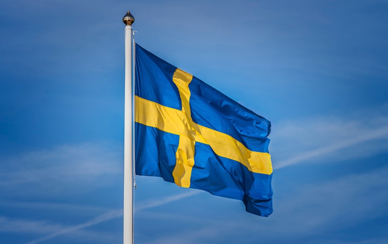 Den svenska blågula flaggan mot blå himmel. Foto: Marie Wennersten, MostPhotos