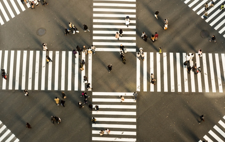 Genre photo: Drone photo of many pedestrians at big crossing. Illustrates research on decisions