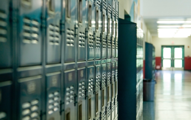 Genrebild: Rader av skåp i en skolkorridor. Illustrerar forskning om teknikstött lärande.