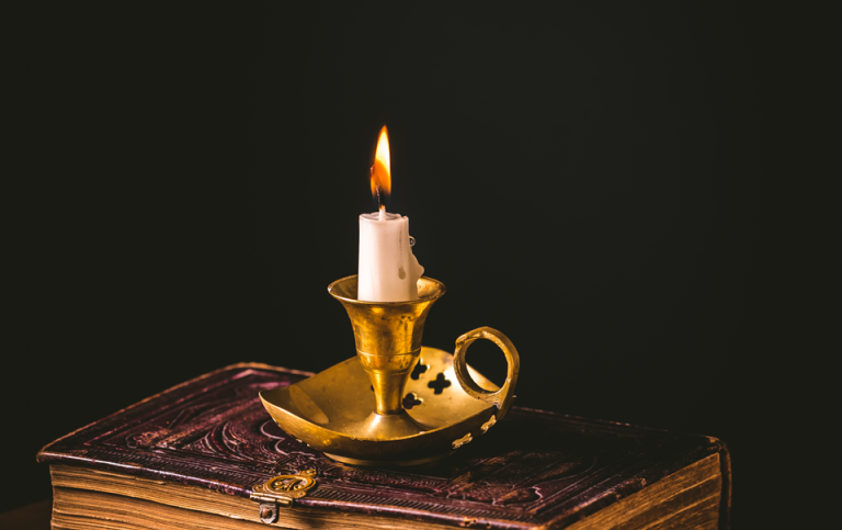 pile of old antique books with candle vintage style