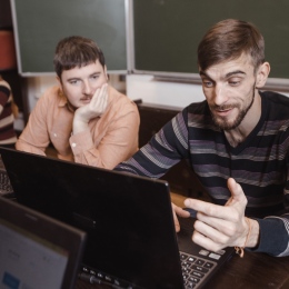 Studenter vid laptop, ser ut att ha roligt.