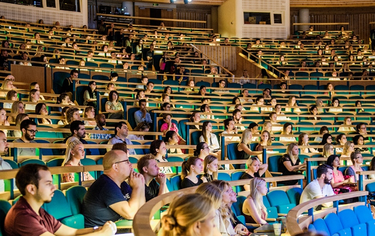 Studenter på läktare i en aula.