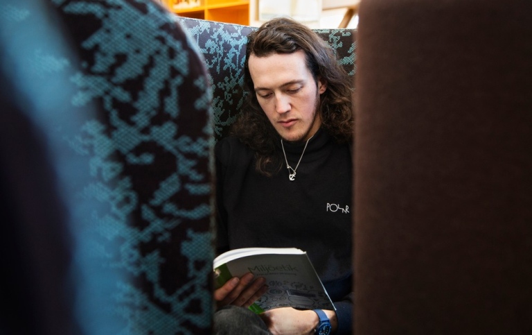 En student sitter och läser i biblioteket.