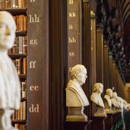 Statyer av filosofer på rad i bibliotek.
