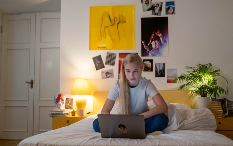 Teenager sitting in her room with laptop