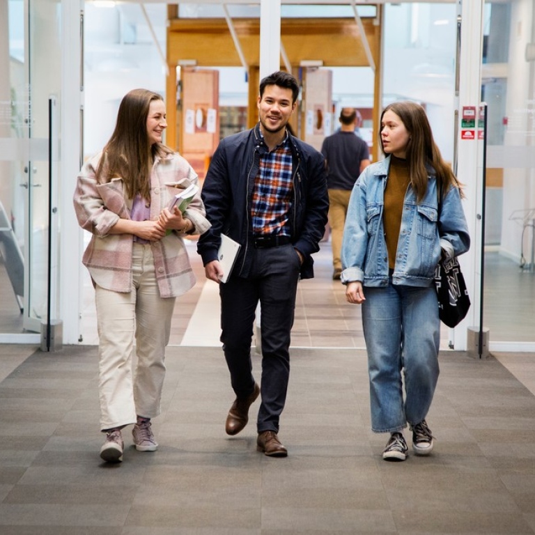 Tre studenter går tillsammans i korridor. Foto: Lena Katarina Johansson. 
