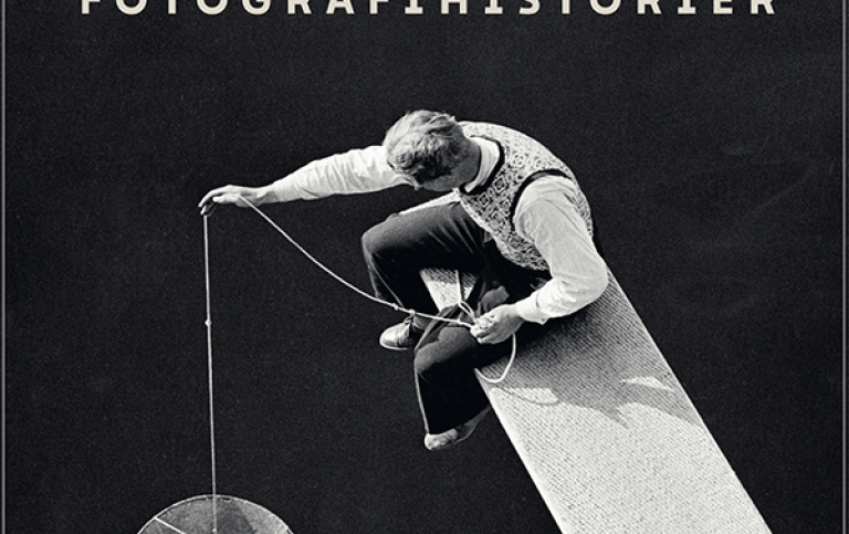 Omslaget till boken Fotografihistorier. Bild på en man som sitter på en planka och sänker ner kärl.