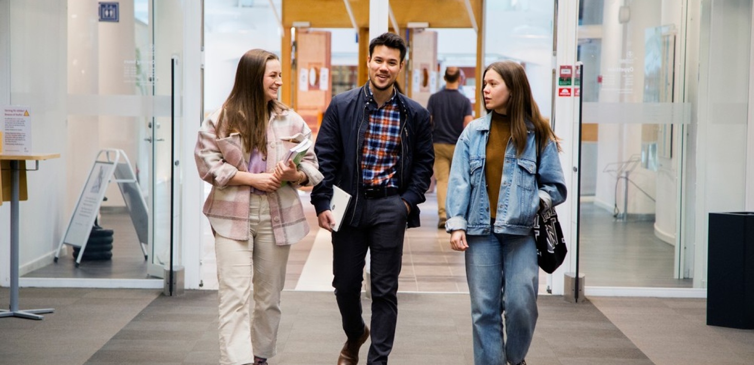 Tre studenter kommer gående i en entré. Foto: Lena Katarina Johansson