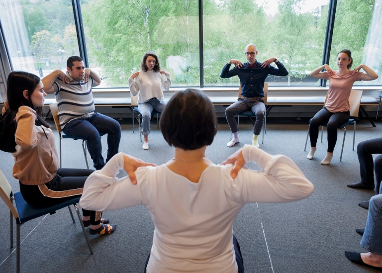 A group of students take a lunchtime yoga class.