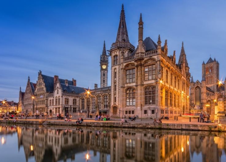 Universiteit Gent-building in the evening with its reflection in the water in front of it